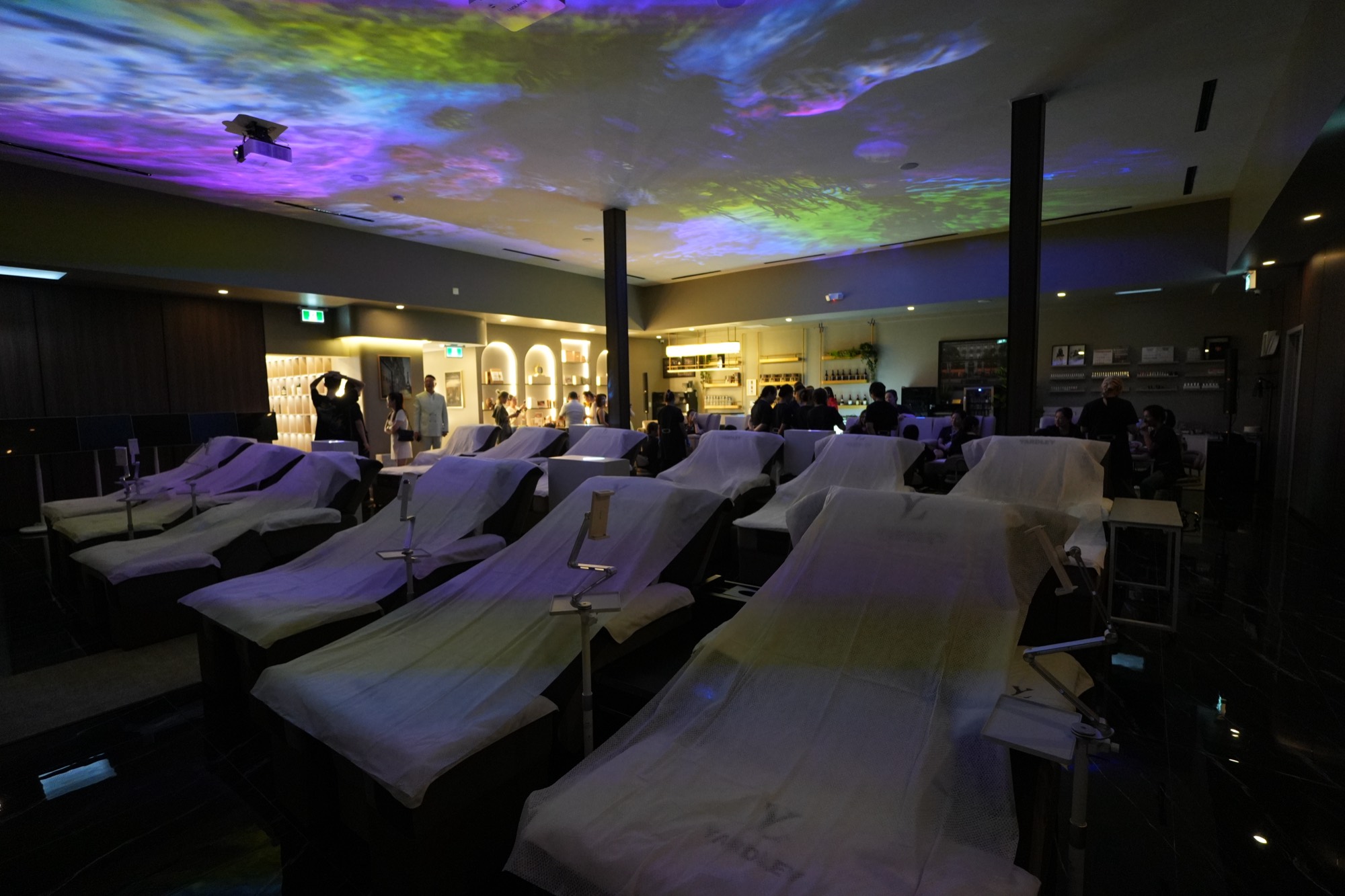 The head spa hall at Yardley, lit by colour projected across the ceiling