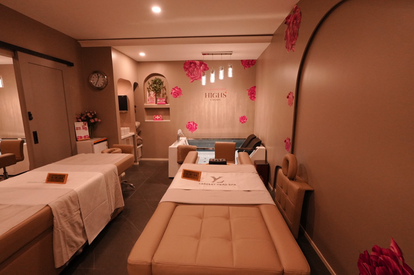 Private treatment room with two massage beds and floral wall detail